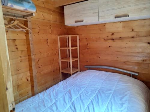 um quarto com uma cama num chalé de madeira em Chalet Le Mazet 