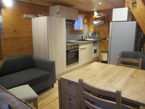 uma cozinha e sala de jantar com uma mesa e um frigorífico em Chalet Le Mazet 
