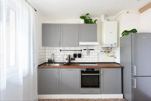 Huge 5-bedrooms apartment near Prague Castle في براغ: مطبخ مع دواليب بيضاء وثلاجة ستانلس ستيل