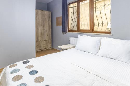 1 dormitorio con cama blanca y ventana en Flat with Backyard 6 min to Bostanci Show Center en Estambul