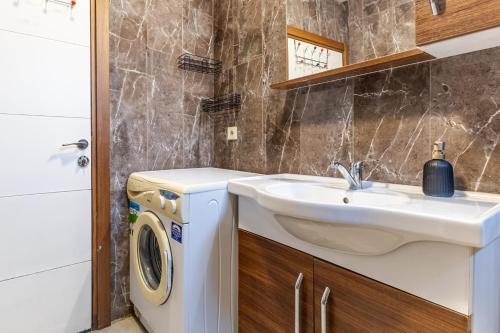 uma casa de banho com um lavatório e uma máquina de lavar roupa em Flat with Backyard 6 min to Bostanci Show Center em Istambul