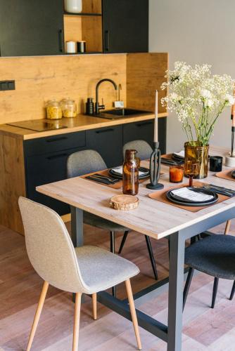 a kitchen with a table with chairs and a sink at Narusa Leśna Przystań in Frombork