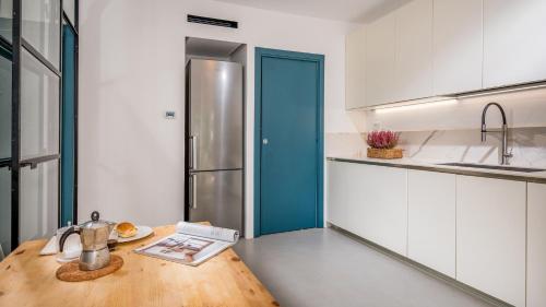 a kitchen with a wooden table and a refrigerator at CASAVENTO PUZZITEDDU 6, Emma Villas in Mazara del Vallo