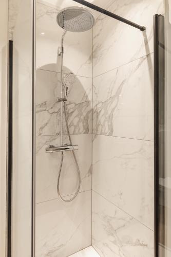 a shower with a glass door with a shower head at Highest Five by Romy&Travis in Bruges