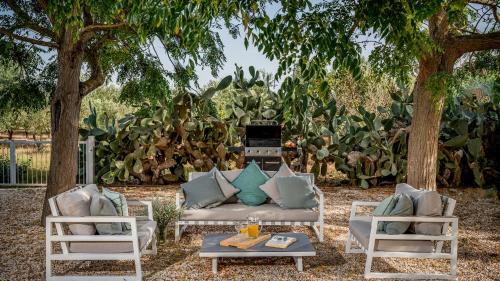 a patio with a couch and two chairs and a table at CASAVENTO PUZZITEDDU 6, Emma Villas in Mazara del Vallo