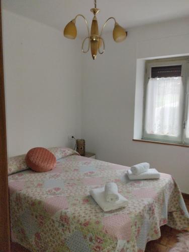 1 dormitorio con 1 cama con toallas en Piso Prado Verde, en Covaleda
