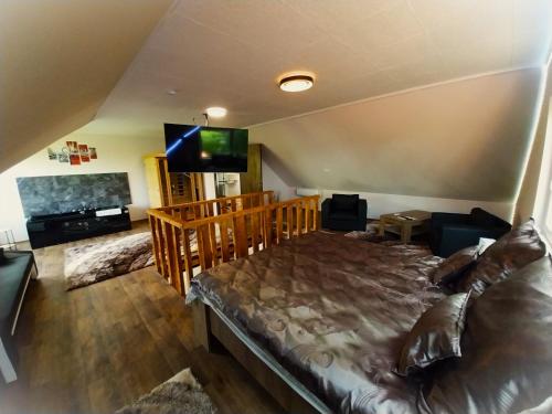 a bedroom with a large bed and a flat screen tv at HUNOR Vendégház in Sátoraljaújhely