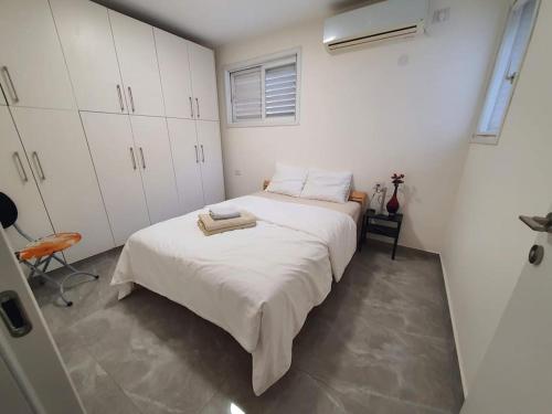 a bedroom with two beds and white cabinets at Renovated central 4 bedroom apt with great terrace and Bomb Shelter in Ramat Gan