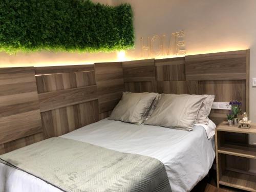 - une chambre avec un lit et une tête de lit en bois dans l'établissement Ronda By Lixloft en el Centro Histórico y Cerca de la Plaza Mayor, à Salamanque