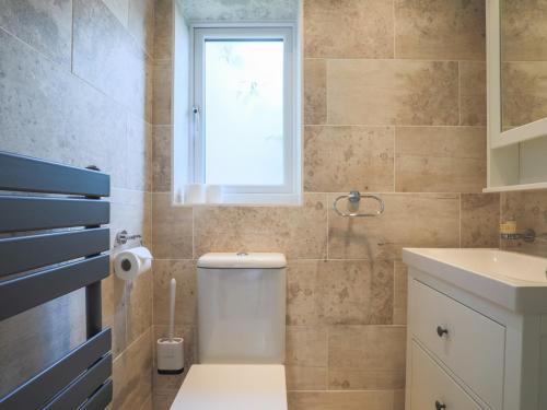 a bathroom with a toilet and a sink and a window at Pass the Keys Cosey 3 Sleeper Flat in Winkfield in Winkfield