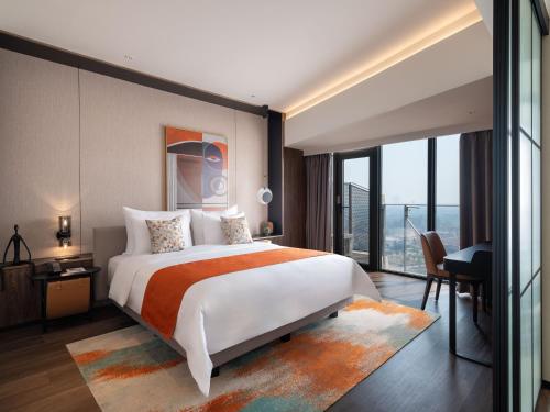 Herloom Hotel & Residence BSD Tangerang في تانغيرانغ: غرفة نوم بسرير كبير ونافذة كبيرة