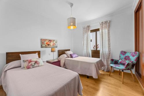 a bedroom with two beds and a table and a chair at Lanzarote Villa Aira in Playa Honda