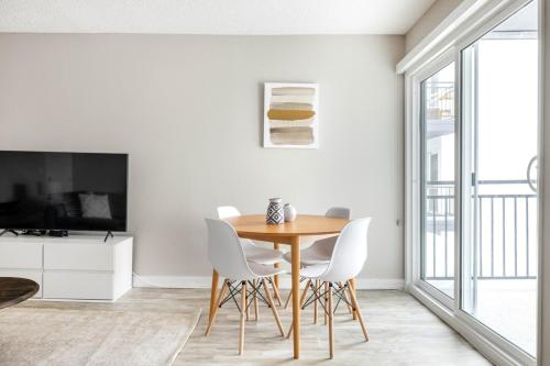 a dining room with a wooden table and white chairs at Redondo Beach 1BR w Pool Gym 1 block from beach LAX-437 in Redondo Beach