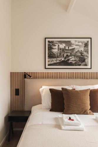 a bedroom with a bed with a picture on the wall at Highest Five by Romy&Travis in Bruges