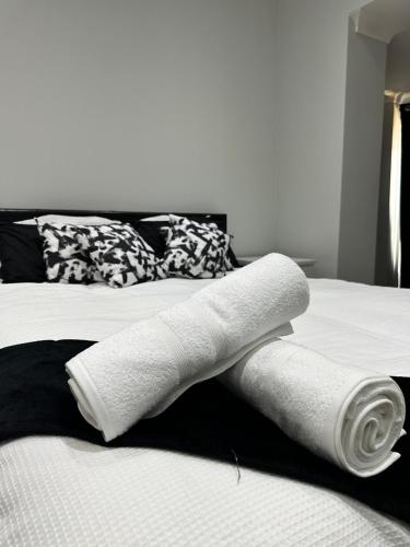 a pile of white towels on top of a bed at Black & White Double Bedroom in London