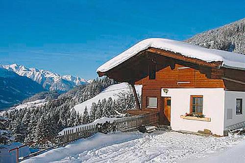 uma cabana de madeira com neve no topo de uma montanha em Almliesl HOLL-154 em Hollersbach im Pinzgau