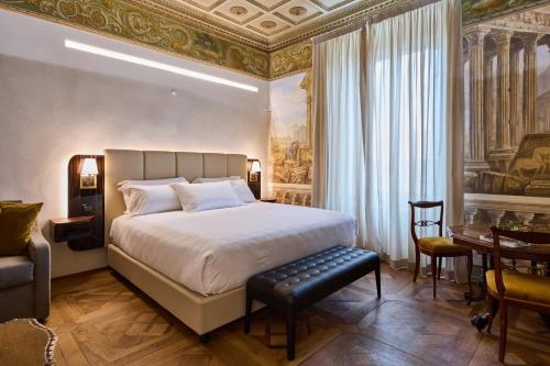 a bedroom with a king sized bed and a table at Duomo Luxury Florence in Florence