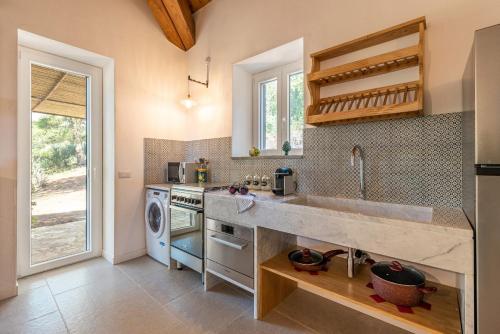 a kitchen with a sink and a dishwasher at Borgo Le Niche by Wonderful Italy in Polizzi Generosa