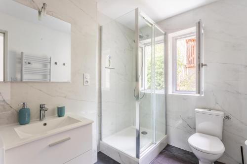 a white bathroom with a shower and a toilet at Le Musée 3, cocooning 2 pièces in Bergerac