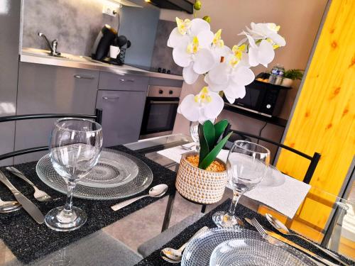 une table avec des verres et un vase de fleurs sur elle dans l'établissement Le Cocon Beauvaisien - Hyper Centre - Wifi Fibre - TV HD, à Beauvais