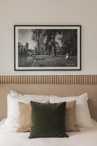 a black and white picture above a bed with pillows at Highest Five by Romy&Travis in Bruges