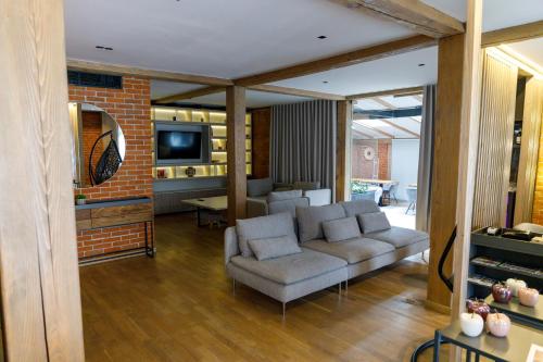 The River Chalet في سيبيل: غرفة معيشة بها أريكة وجهاز تلفزيون