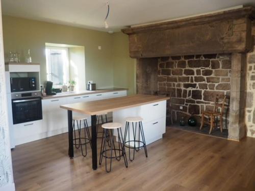 une cuisine avec une table et des tabourets dans une pièce dans l'établissement #Villa LeCalmeDuVerdier - Spatieuse et Lumineuse, à Tudeils