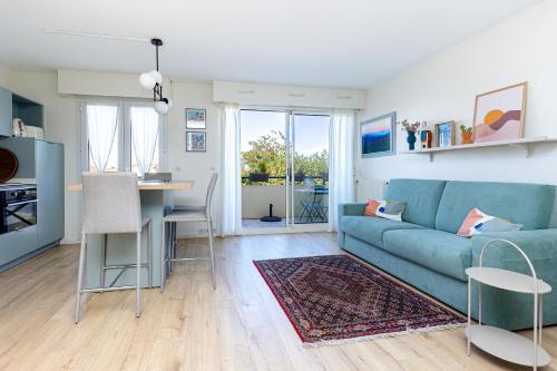 a living room with a blue couch and a table at Appart Anglet in Anglet