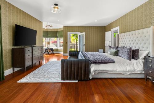 a bedroom with a large bed and a flat screen tv at Montecito Hamptons Style Gated Resort - Steps from the Beach in Montecito