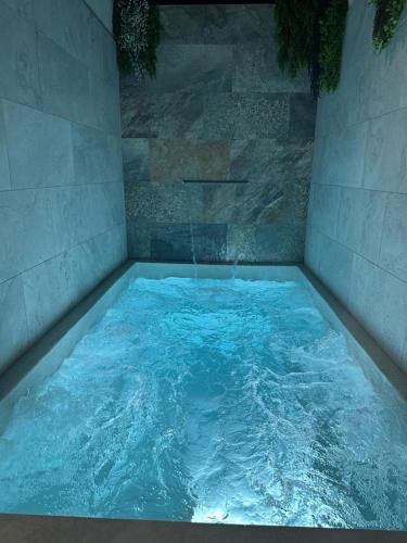 a large pool of blue water in a room at Huellas de la Mancha in Burguillos de Toledo