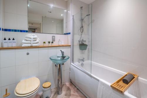 a bathroom with a sink and a toilet and a tub at Mailbox 2 bed Apartment Birmingham City Centre - Free Parking in Birmingham