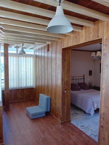 a bedroom with a bed and a blue chair at Casa Grande Zona Norte in Jerez de la Frontera