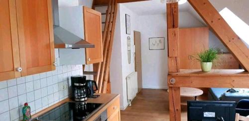 a kitchen with wooden cabinets and a stove top oven at Ferienwohnung Helene in Gifhorn