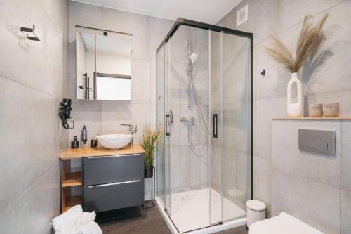 a bathroom with a shower and a sink at Narusa Leśna Przystań in Frombork