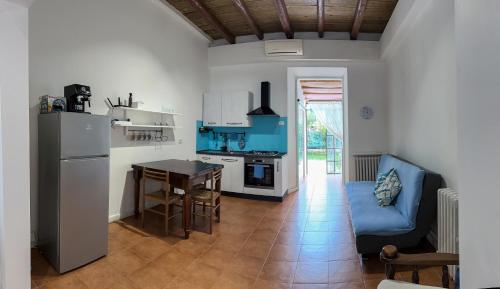 una cucina con tavolo e divano blu in una camera di Host4All casa vacanze a Falconara Marittima