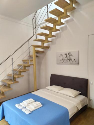 a bedroom with a bed and a staircase at Двоповерхові апартаменти Мілена у центрі з балконом та паркінгом in Lviv