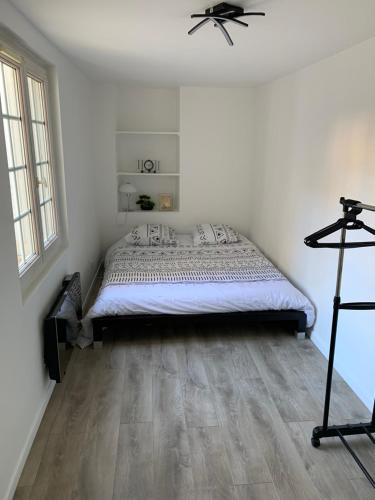 une chambre avec un lit et un parquet dans l'établissement Jolie 2 pièces avec terrasse jusqu'à 5 personnes Nancy centre, à Nancy