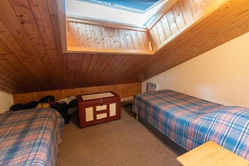 Cette chambre mansardée comprend 2 lits et une lucarne. dans l'établissement Paradiski - Flat with mountain views, à Champagny-en-Vanoise