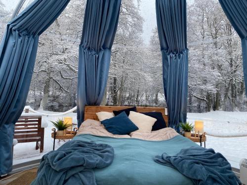 a bedroom with a bed with blue curtains and snow at Borås Camping & Vandrahem in Borås