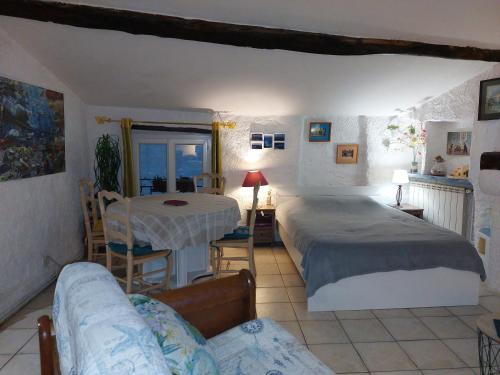 a bedroom with two beds and a table and a couch at "Le charme provençal" - Studio 4 couchages classé 2 étoiles - Axelle Loc'Appart in Lorgues