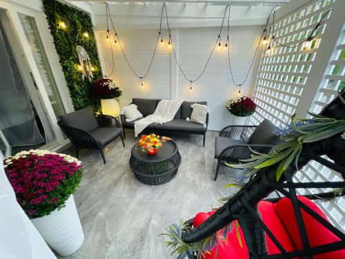a living room with a couch and chairs and flowers at Aici te simți ca acasa 2 in Iaşi