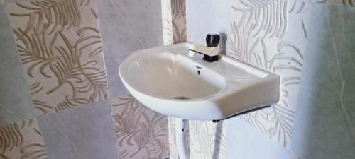 um lavatório branco na casa de banho com uma cortina de chuveiro em Poddar Retreat Managed by Wheels And Wings em Dām Dim
