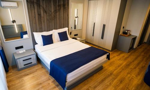 a bedroom with a large bed with blue pillows at Elina Managed by Dedeman in Atakum