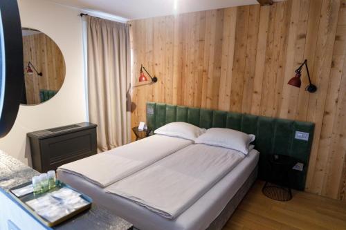 a bedroom with a bed in a room with wooden walls at The River Chalet in Sibiel