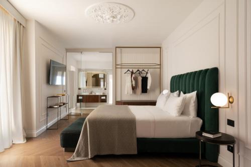 a bedroom with a large bed with a green headboard at Patria Palace Lecce - The Leading Hotels of The World in Lecce
