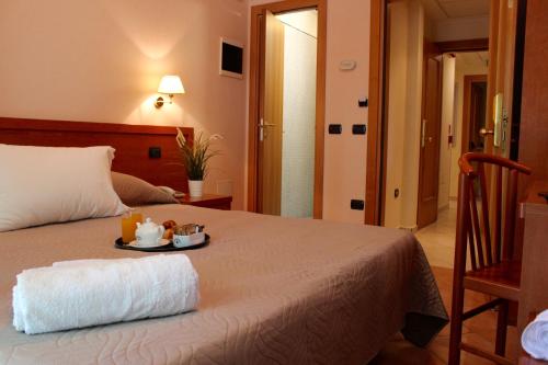a bedroom with a bed with a tray of food on it at Jole Beach Hotel in Cesenatico