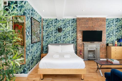 a bedroom with a bed and a fireplace at Crashpads Shoreditch Brick Lane Mini Lofts in London