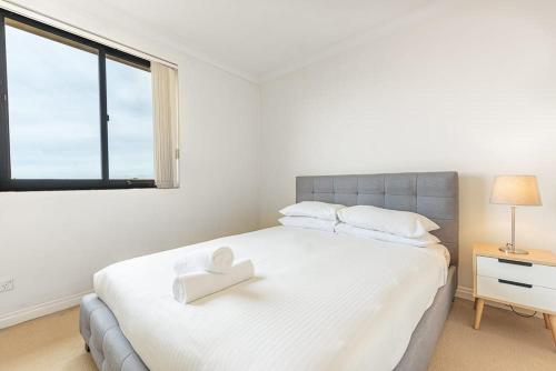 a bedroom with a white bed with a heart on it at 1BD Apt w City view in the Little Italy in Sydney