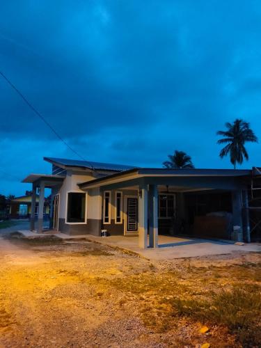 a house with a palm tree in front of it at NAYLA Homestay Perlis in Simpang Empat
