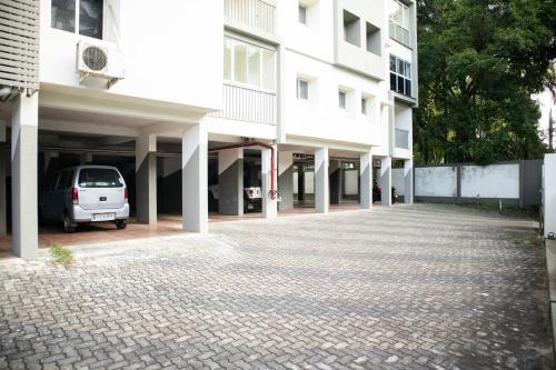 a car parked in a parking lot next to a building at Elite Dharshan H5 - AC 2 BHK Apartment near Guruvayur Temple in Guruvāyūr
